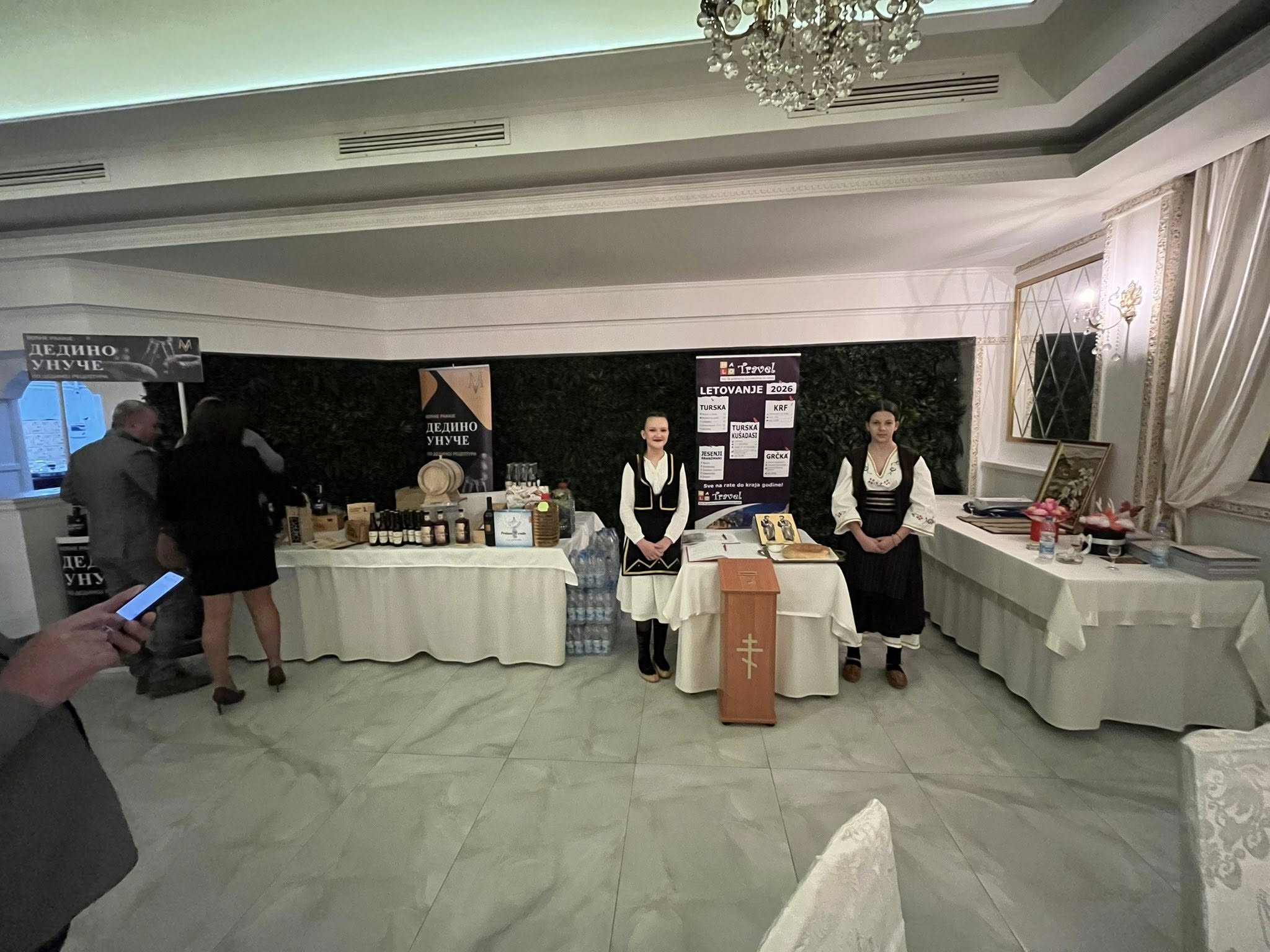 Девојке у топличким народним ношњама поред донаторске кутије и иконе